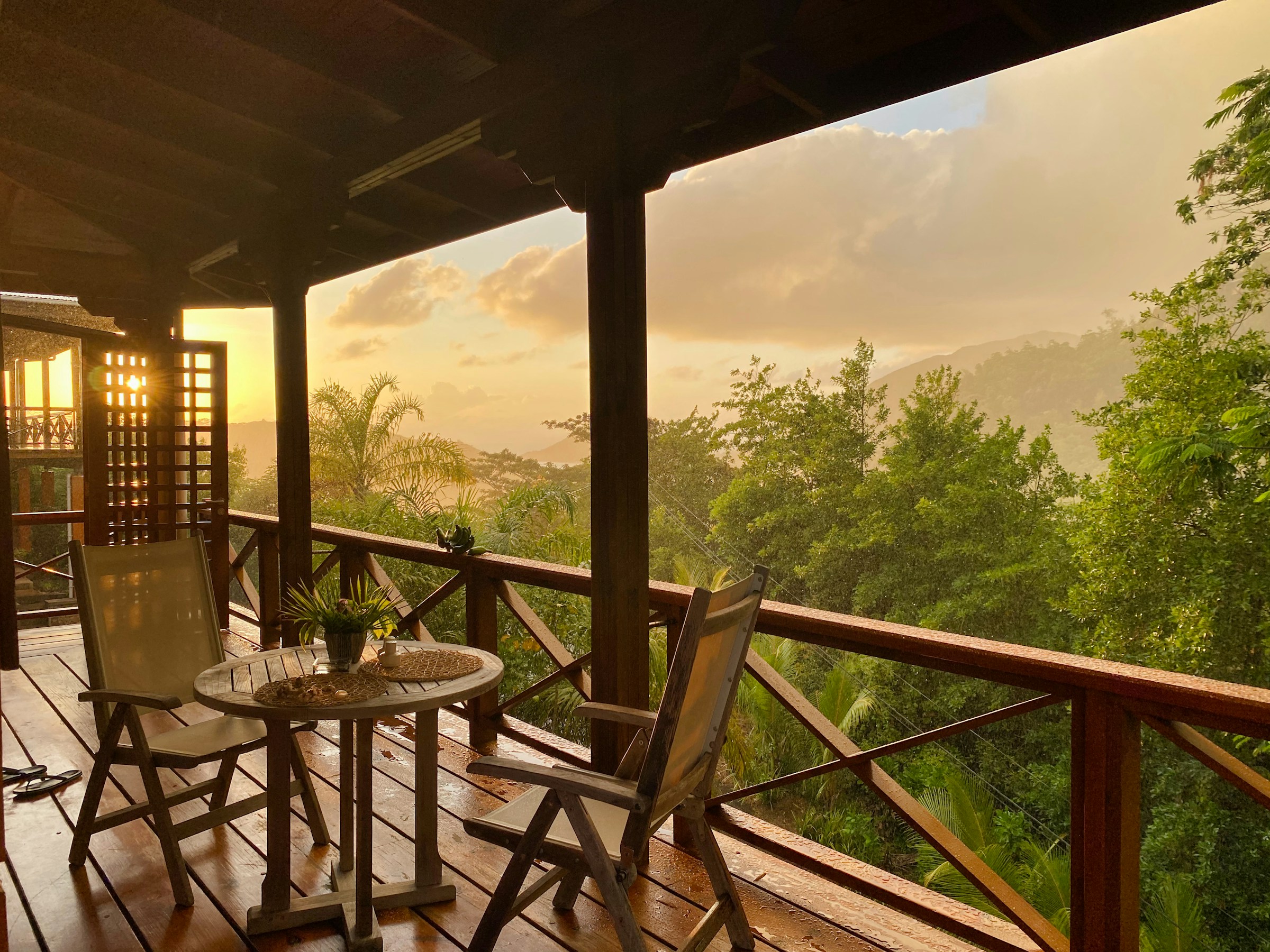A wooden table and chairs overlooking a natural coastal setting